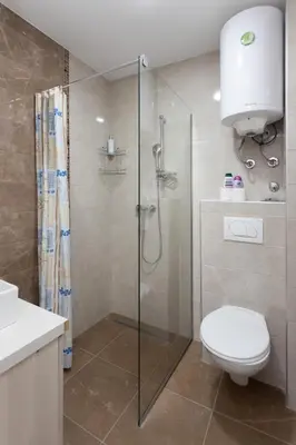 a bathroom with a toilet and a glass shower at Ibis Lux Milmari Apartman N51 Kopaonik Panorama Spa in Kopaonik