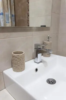 a white bathroom sink with a basket on it at Ibis Lux Milmari Apartman N51 Kopaonik Panorama Spa in Kopaonik