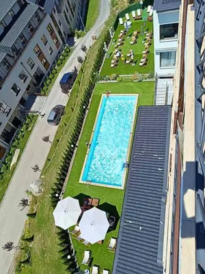 an overhead view of a swimming pool with umbrellas at Ibis Lux Milmari Apartman N51 Kopaonik Panorama Spa in Kopaonik