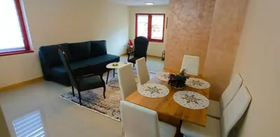 a living room with a table and chairs and a couch at Apartmani Vujanac in Kopaonik