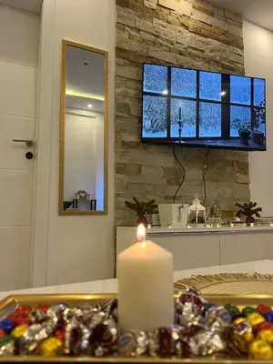 a candle sitting on a table in a kitchen with a window at Milmari N lux Sena in Kopaonik
