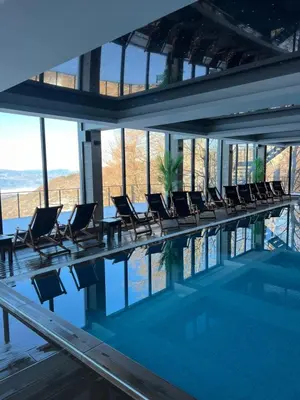 a swimming pool with chairs in a building at Milmari N lux Sena in Kopaonik