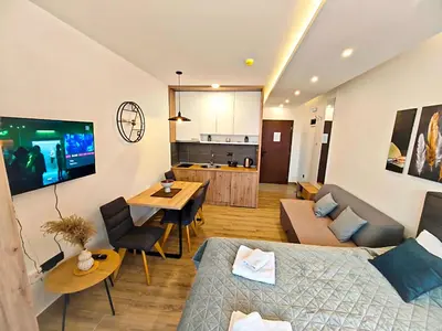 a living room with two beds and a dining room at Harmony, Residence Hill A85 in Kopaonik