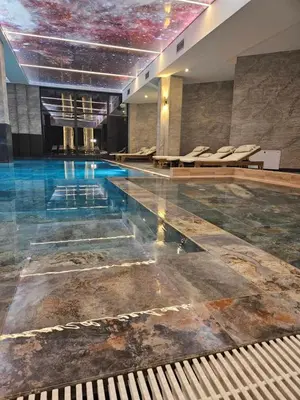 a swimming pool with chairs in a building at Harmony, Residence Hill A85 in Kopaonik
