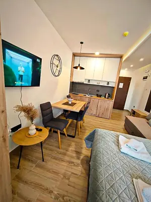 a living room with a table and a tv in it at Harmony, Residence Hill A85 in Kopaonik