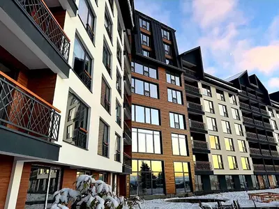 a building with snow on the ground in front of it at Kopaonik-Residence Hill Repnica A71 in Cajetina