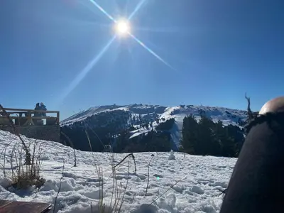 a snow covered mountain with the sun in the sky at Kopaonik-Residence Hill Repnica A71 in Cajetina