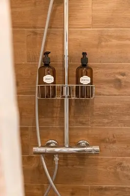 two bottles of soap on a shelf in a bathroom at Glečer Kop, Apartment A14, FREE Parking Garage in Kopaonik