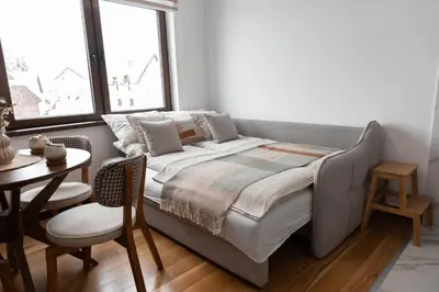 a bed in a room with a table and a window at Glečer Kop, Apartment A14, FREE Parking Garage in Kopaonik
