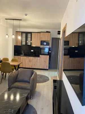a kitchen and living room with a couch and a table at Pogled Apartman Kopaonik in Kopaonik