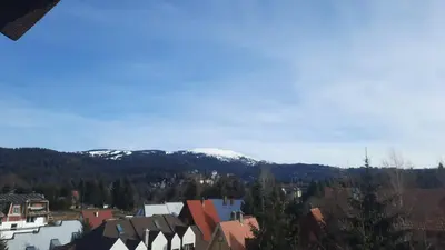 a view of a town with a snow covered mountain at Pogled Apartman Kopaonik in Kopaonik