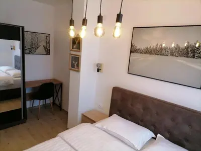 a bedroom with a bed and a picture on the wall at Pogled Apartman Kopaonik in Kopaonik