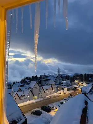 a view of a city in the snow from a window at Pogled Apartman Kopaonik in Kopaonik