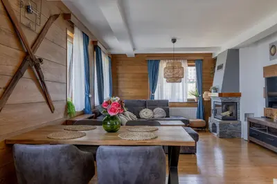 a living room with a table and chairs and a couch at Apartman Rustic 85m2 in Kopaonik