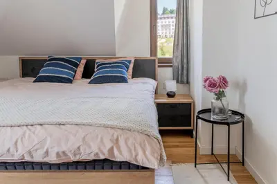 a bedroom with a bed with blue pillows and a table at Apartman Rustic 85m2 in Kopaonik