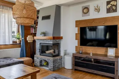 a living room with a fireplace and a television at Apartman Rustic 85m2 in Kopaonik