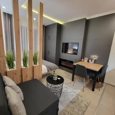 a living room with a bed and a dining room at PIK Apartmani - Milmari in Kopaonik