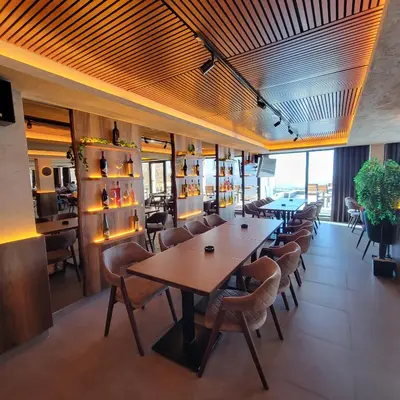 a restaurant with tables and chairs in a room at PIK Apartmani - Milmari in Kopaonik