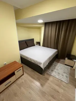 a small bedroom with a bed and a table at Kop apartman I01 in Kopaonik