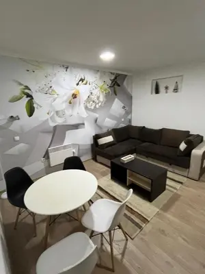 a living room with a couch and a table and chairs at Kop apartman I01 in Kopaonik