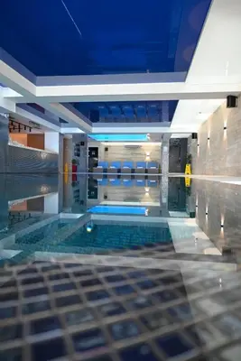 a swimming pool in a building with a blue ceiling at Kop apartman I01 in Kopaonik