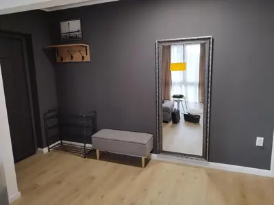 a living room with a mirror and a ottoman at Home apartment in Niš