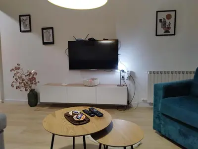 a living room with a tv and a coffee table at Home apartment in Niš