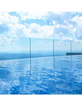 a swimming pool with blue water and a cloudy sky at Apartman Adut Kop. in Kopaonik