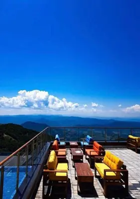 a group of people sitting on a deck overlooking the mountains at Apartman Adut Kop. in Kopaonik
