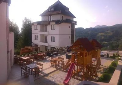 a building with a playground with tables and a slide at Apartman Adut Kop. in Kopaonik