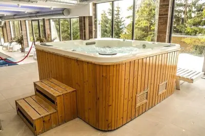 a jacuzzi tub in a room with windows at Sunčani breg resort & spa in Kopaonik
