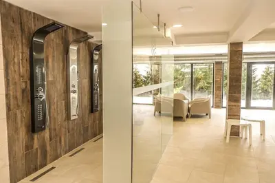 a lobby with a glass door and a table and chairs at Sunčani breg resort & spa in Kopaonik
