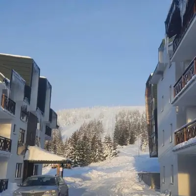 a car parked next to a building in the snow at Sunčani breg resort & spa in Kopaonik