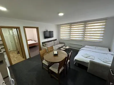 a bedroom with a bed and a table and a couch at Sunčani breg resort & spa in Kopaonik