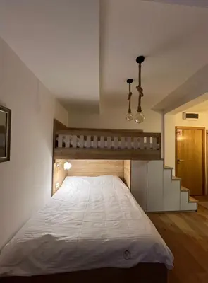 a bedroom with a bed and a stair case at Studio M in Kopaonik