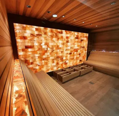 an empty sauna with a stone wall and benches at Studio M in Kopaonik
