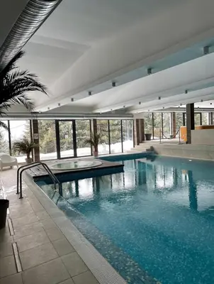 a large swimming pool with blue water in a building at Studio M in Kopaonik