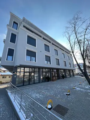 a large white building with pigeons in front of it at Apartmani Central 11 & Free parking in Vrnjačka Banja