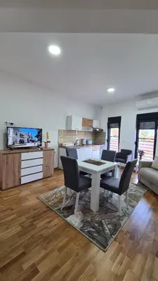 a kitchen and living room with a table and chairs at Apartmani Central 11 & Free parking in Vrnjačka Banja