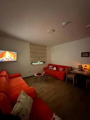 a living room with a red couch and a table at Silver Pine Kopaonik in Kopaonik