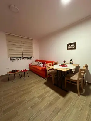 a living room with a red couch and a table at Silver Pine Kopaonik in Kopaonik