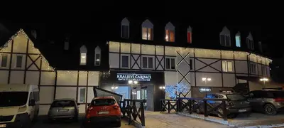 a building with cars parked in front of it at night at Apartman Jovanovic,Kopaonik in Kopaonik