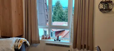 a window with a view of a building at Apartman Jovanovic,Kopaonik in Kopaonik