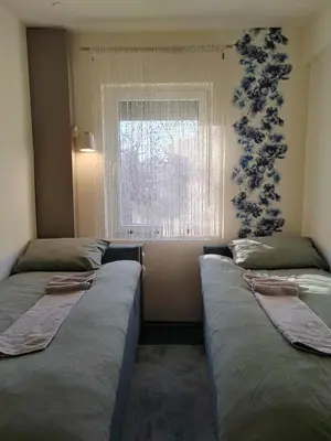 two beds in a room with a window at Apartman Stanimirović 3 in Zaječar
