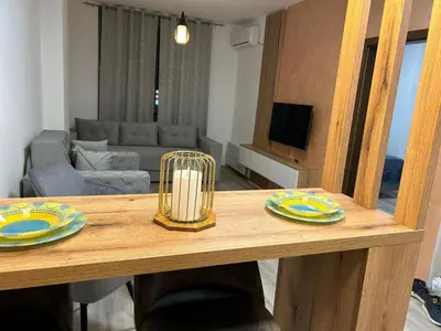 a wooden table with two plates and a candle on top at De Lux Nedeljkovic President in Jagodina