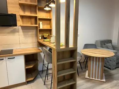 a small kitchen with a table and a table and a counter at De Lux Nedeljkovic President in Jagodina