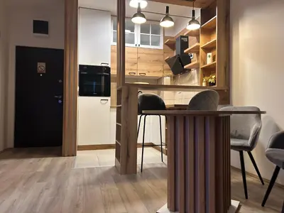 a kitchen with a table and some chairs in a room at De Lux Nedeljkovic President in Jagodina