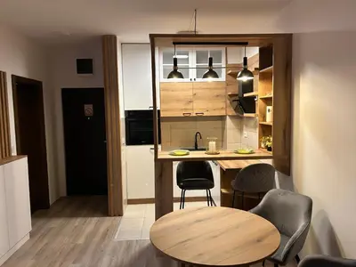 a small kitchen with a table and chairs in a room at De Lux Nedeljkovic President in Jagodina