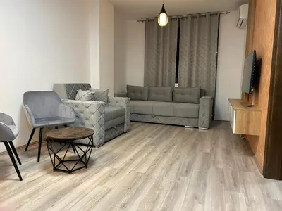 a living room with a couch and a tv at De Lux Nedeljkovic President in Jagodina