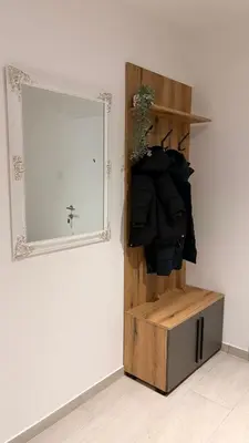 a mirror on a wall next to a wooden shelf at Central Apartments in Zaječar